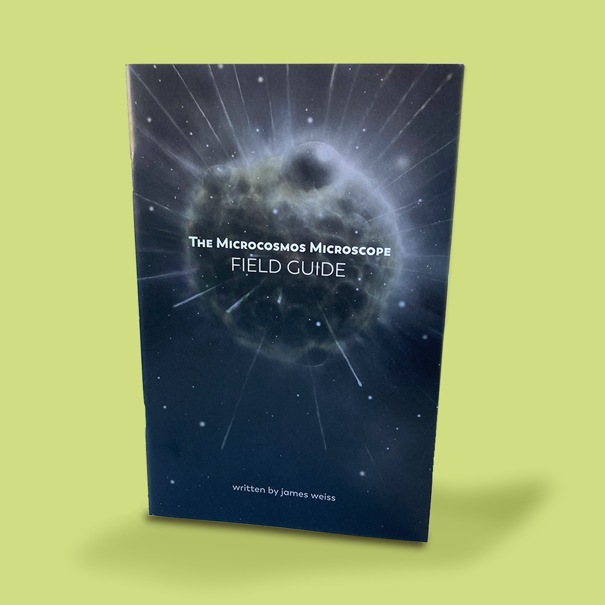 Photograph of book featuring the words "The Microcosmos Microscope Field Guide, written by James Weiss" on the cover